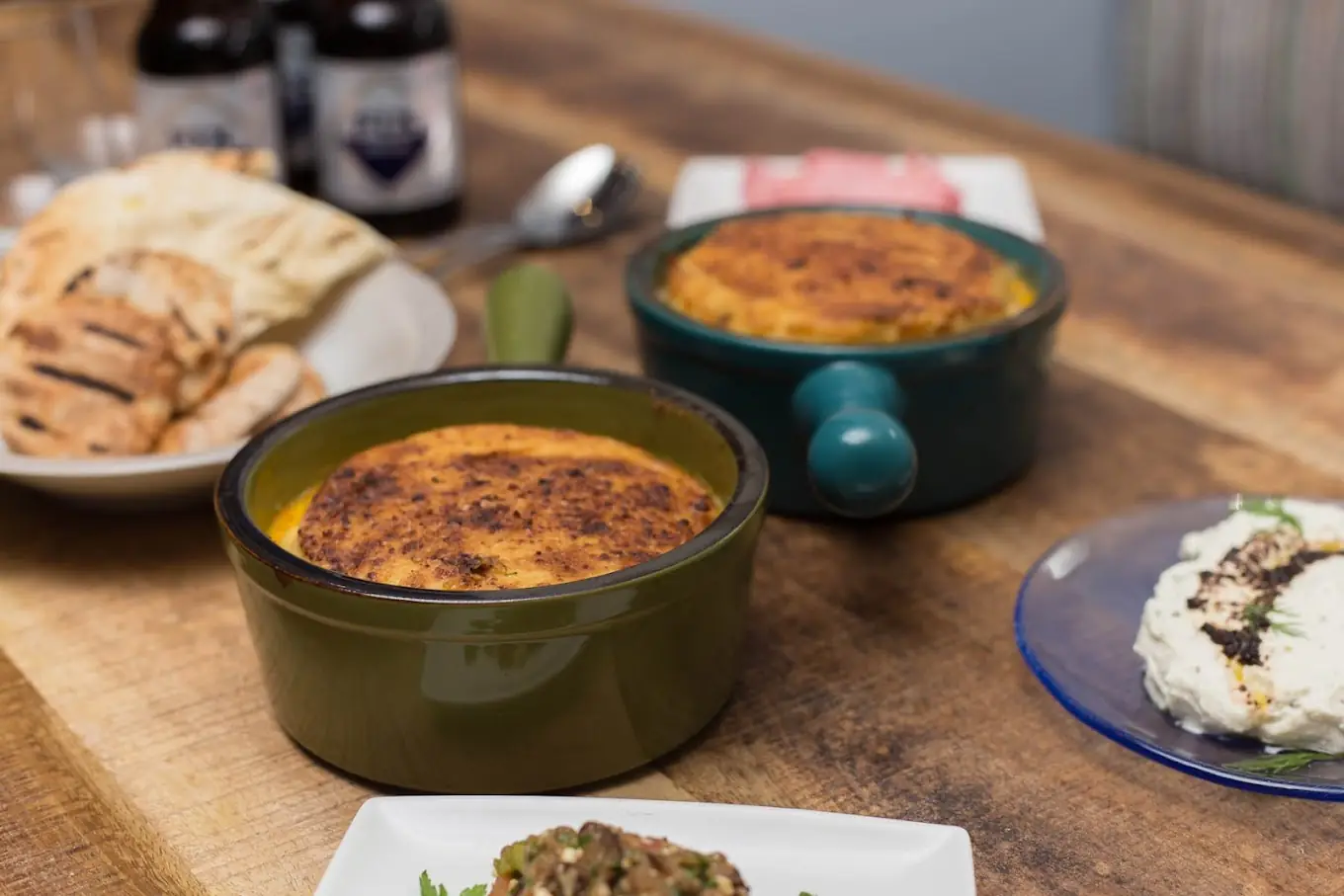 Moussaka traditionnelle gratinée, servie avec pita grillée et bière FIX Hellas